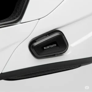 Close-up view of a sleek Bluetooth communication module seamlessly integrated into the side of a white motorcycle helmet.