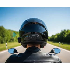 A rider in a modern black motorcycle helmet with integrated Bluetooth, clearly showing the control panel, enjoying a clear road ahead.