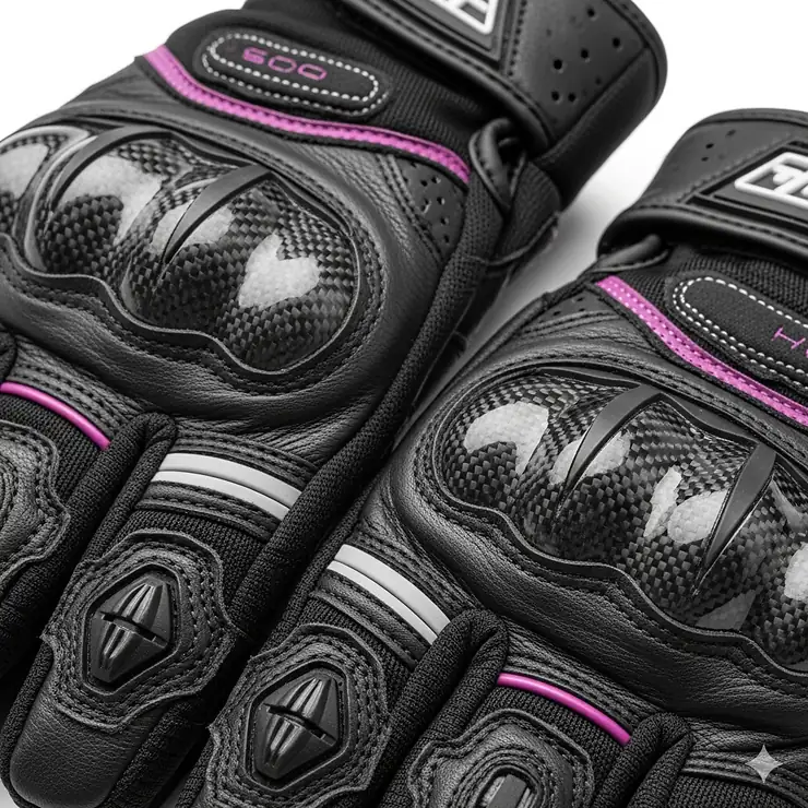 Close-up of protective features on a pair of women's motorcycle gloves, highlighting the carbon fiber knuckle protection and palm sliders.