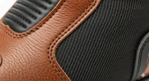 A close-up of the high-quality, full-grain leather and textile materials used in the construction of waterproof motorcycle boots, showcasing their durability.