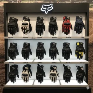 A display of various Fox motorcycle gloves models, showcasing their different colors and designs.