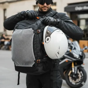 A rider easily attaching a full-face helmet to the external, secure carry net or flap of the motorcycle helmet backpack.
