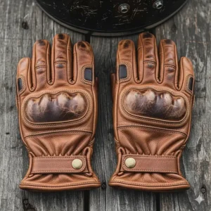 A pair of classic, distressed brown leather motorcycle gloves with a vintage aesthetic.