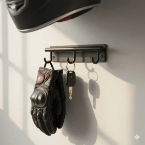 Close-up view of the integrated hooks on the helmet wall mount designed for hanging gloves and keys.