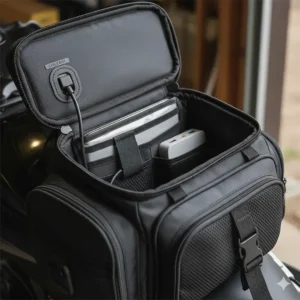 Internal view of a motorcycle tank bag showing organized compartments and a dedicated cable port for charging electronics.