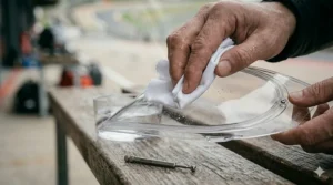 Illustration showing the proper way to clean a Pinlock lens using lukewarm water and a microfiber cloth.