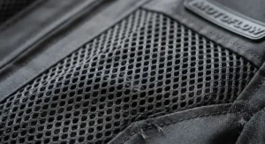 Detailed macro close-up showing the durable, tear-resistant weave of a premium summer motorcycle jacket mesh fabric.