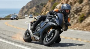 A sportbike rider leaning into a turn on a highway wearing a full-airflow ventilated motorcycle jacket.