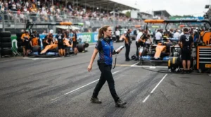 Racer walking down the pit lane wearing durable budget racing boots for amateur racers