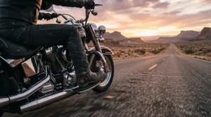 Rider cruising down a desert highway wearing comfortable long distance motorcycle boots for wide feet.