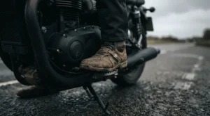 Close-up of stealth black motorcycle sneakers that look like normal shoes resting on a motorcycle footpeg.