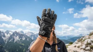 Perforated leather and mesh summer motorcycle riding gloves held up against a blue sky