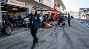 A racer walking through the pit lane wearing comfortable racing boots for short riders.