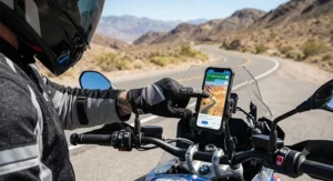 Rider tapping smartphone navigation screen while wearing touchscreen-compatible summer motorcycle gloves