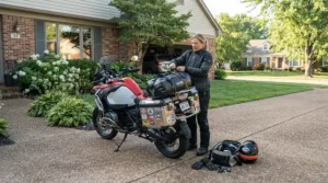 A rider packing saddlebags and lacing up touring boots for long distance comfort before a trip.
