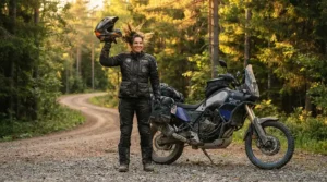 A smiling motorcyclist finishing a long ride in touring boots for long distance comfort.