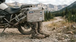 A mud-splattered pair of affordable adventure riding boots demonstrating exceptional boot longevity after years of touring.