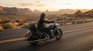 A rider wearing tall women's motorcycle boots for cruiser riders while cruising down an open desert highway at sunset.
