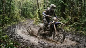 A rider wading through a deep swamp wearing waterproof adventure boots for mud on a dual-sport motorcycle.