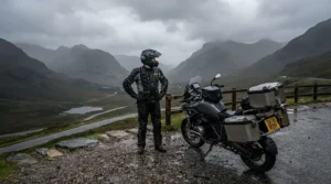 Long-distance touring rider wearing waterproof women's motorcycle boots for rain through a rural mountain pass.